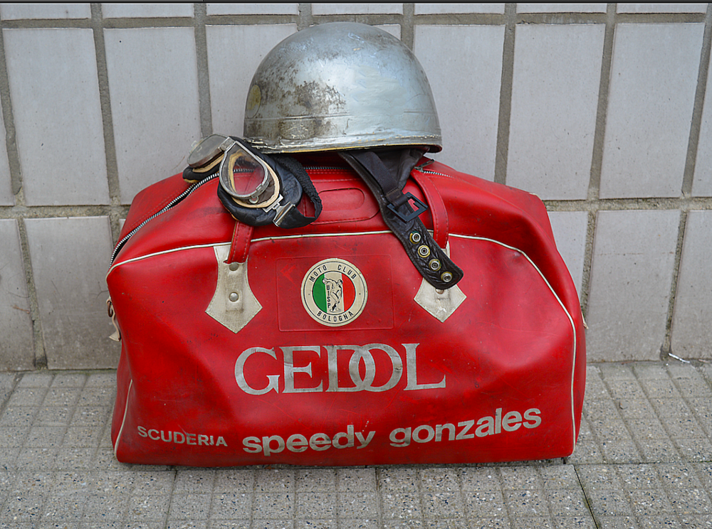 Una moto rimediata in qualche modo e la borsa con casco a scodella, tuta nera, stivaletti, guanti e occhiali era quanto serviva per andare a correre. Attorno alla metà degli anni Sessanta pochi team potevano sfoggiare una borsa “dedicata”