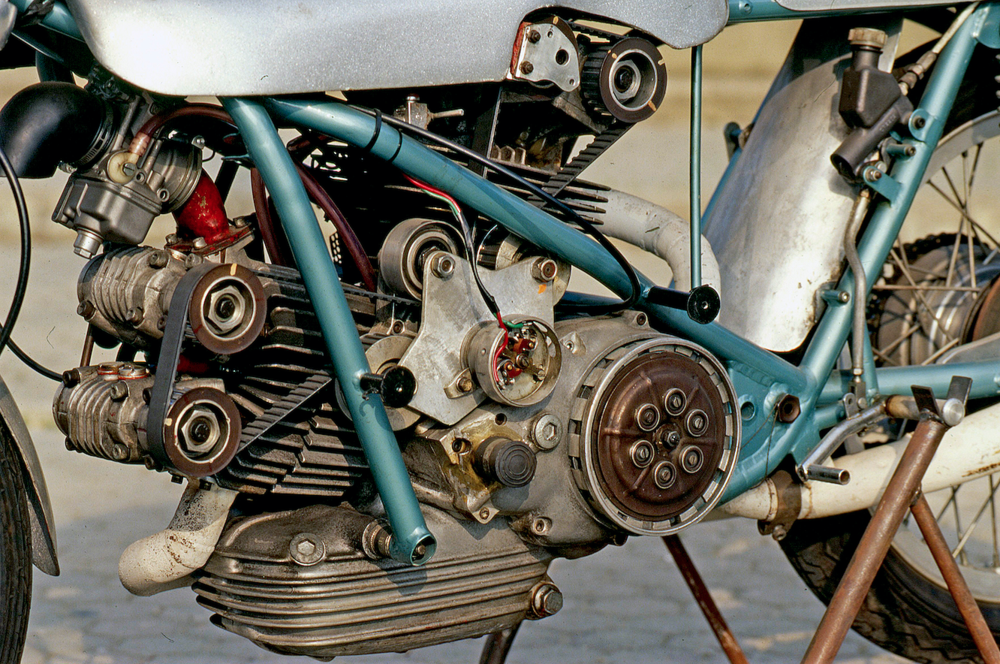 Nel 1972 il tecnico Renato Armaroli ha realizzato per la Ducati una versione del bicilindrico 500 da GP con quattro valvole per cilindro, teste bialbero (non desmo) e comando della distribuzione a cinghia dentata. Il condotto di aspirazione del cilindro verticale era rivolto anteriormente