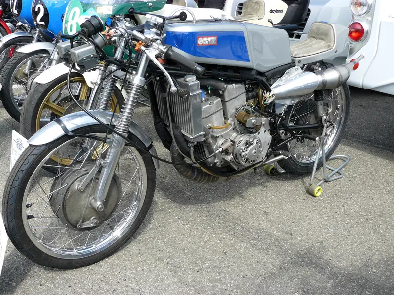 Nel 1969 la MZ ha proposto per prima l&rsquo;architettura in tandem per le bicilindriche a disco rotante, ripresa anni dopo da Kawasaki e Rotax. In questa 125, che pare erogasse oltre 32 CV, i due alberi a gomito ruotano nello stesso verso e sono in presa con un albero ausiliario, alla cui estremit&agrave; &egrave; montata la frizione