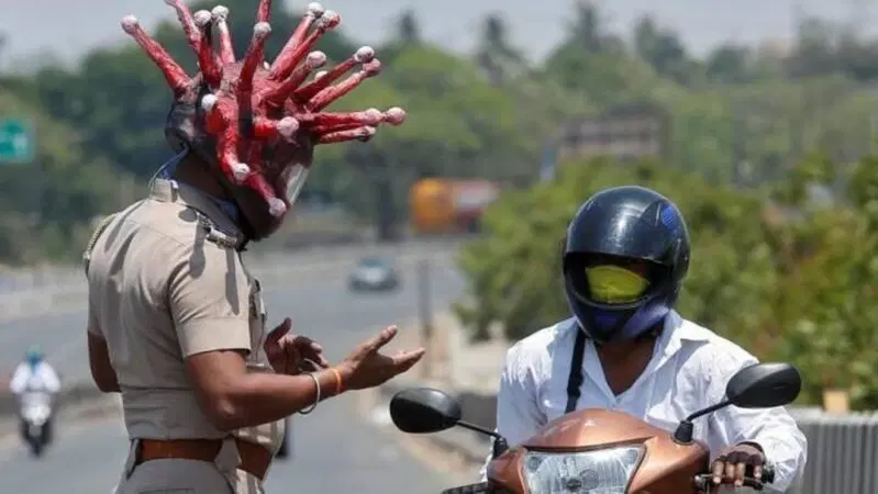 La Polizia indiana travestita da virus "attacca" i motociclisti