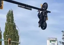 Incredibile incidente in Canada; la moto resta appesa al semaforo